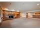Spacious basement living area featuring a brick fireplace, built-in cabinets, and carpet flooring at 101 Glenmoor Ln, Cherry Hills Village, CO 80113