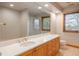 Bathroom featuring a large mirror, wooden cabinets, and neutral paint at 101 Glenmoor Ln, Cherry Hills Village, CO 80113