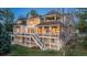 Large two-story brick home with a large deck and stairs leading down to a manicured lawn at 101 Glenmoor Ln, Cherry Hills Village, CO 80113
