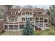 Rear exterior view of large two-story brick home featuring a deck and stairs at 101 Glenmoor Ln, Cherry Hills Village, CO 80113