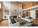 Inviting living room featuring a stone fireplace, hardwood floors, high ceilings, and neutral toned furniture at 101 Glenmoor Ln, Cherry Hills Village, CO 80113