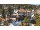 A bird's eye view of a house with a large deck and patio surrounded by trees at 1366 Killington Ct, Evergreen, CO 80439