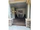 Inviting covered front porch with stone pillars, decorative wreath and two black lanterns at 1366 Killington Ct, Evergreen, CO 80439