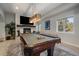 Bright game room featuring a stone fireplace, mounted television and a beautiful billiard table at 1366 Killington Ct, Evergreen, CO 80439