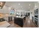 Open kitchen with an island, modern appliances, white cabinets, and open view to the living room at 1366 Killington Ct, Evergreen, CO 80439