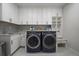 Modern laundry room has built in shelving, sink and modern washer and dryer at 1366 Killington Ct, Evergreen, CO 80439