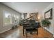 Sophisticated living room with a grand piano, hardwood floors, and natural light at 1366 Killington Ct, Evergreen, CO 80439