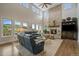 Bright living room with stone fireplace, high ceilings, large windows, and leather sofas at 1366 Killington Ct, Evergreen, CO 80439