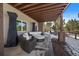 Covered patio with comfortable seating and a round coffee table, surrounded by serene views at 1366 Killington Ct, Evergreen, CO 80439