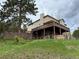 Expansive rear exterior of the home with a large wooden deck overlooking a sprawling backyard at 1366 Killington Ct, Evergreen, CO 80439