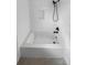 Modern bathroom showcasing a bathtub with white tile surround and updated fixtures at 1479 S Bellaire St, Denver, CO 80222
