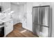 Kitchen with white cabinets, stainless steel refrigerator and hardwood floors at 1479 S Bellaire St, Denver, CO 80222