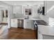 Modern kitchen with stainless steel appliances, white shaker cabinets, quartz counters and hardwood floors at 1479 S Bellaire St, Denver, CO 80222
