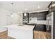 Kitchen with dark cabinets, stainless appliances and quartz island at 1595 Orchard St, Brighton, CO 80601