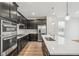 Spacious kitchen features black cabinetry, stainless appliances, and long island at 1595 Orchard St, Brighton, CO 80601