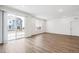 Spacious living room with wood flooring, large window, and sliding glass door at 1595 Orchard St, Brighton, CO 80601