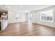 Sunlit open floor plan with wood floors, white walls, and sliding glass doors to the backyard at 1595 Orchard St, Brighton, CO 80601
