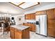 Spacious kitchen with island, wooden cabinets, stainless steel fridge, and adjacent dining area at 9810 Venneford Ranch Rd, Highlands Ranch, CO 80126