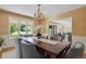 Elegant dining room with chandelier, large windows offering backyard views, and seating for six guests at 5196 S Williams Dr, Greenwood Village, CO 80121