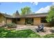 Charming single-story home with a well-kept lawn, mature landscaping, and inviting patio area with seating at 5196 S Williams Dr, Greenwood Village, CO 80121