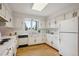 Traditional kitchen featuring white cabinetry, wooden floors, modern appliances, and a bright window above the sink at 5196 S Williams Dr, Greenwood Village, CO 80121