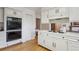 Bright kitchen featuring white cabinets, built-in ovens, and a cooktop on the spacious countertop at 5196 S Williams Dr, Greenwood Village, CO 80121