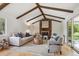 Inviting living room boasts wood beams, a stone fireplace, and comfortable seating with natural light and backyard views at 5196 S Williams Dr, Greenwood Village, CO 80121