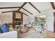 Cozy living room featuring a stone fireplace, wood beams, and comfortable seating with backyard access at 5196 S Williams Dr, Greenwood Village, CO 80121