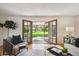 Bright living room with French doors opening to a green backyard, creating a seamless connection with nature at 5196 S Williams Dr, Greenwood Village, CO 80121
