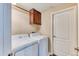 Practical laundry room featuring a washer, dryer, overhead cabinets, and adjacent storage closet at 31101 Black Eagle Dr # 202, Evergreen, CO 80439