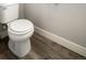 Close up of the white toilet in a bathroom with wood-look vinyl floors at 16069 E Elk Dr, Denver, CO 80239