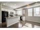 Bright kitchen featuring sleek, black appliances, white cabinetry, granite countertops, and abundant natural light at 16069 E Elk Dr, Denver, CO 80239