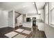 Sunlit, modern kitchen featuring white cabinets, black appliances, and a seamless flow into a spacious living area at 16069 E Elk Dr, Denver, CO 80239