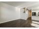 Spacious living area with dark wood floors leading to a modern kitchen and staircase, creating an open layout at 16069 E Elk Dr, Denver, CO 80239