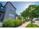 Modern gray house with an inviting tree-lined street view, enhanced by lush landscaping and a well-kept sidewalk at 16069 E Elk Dr, Denver, CO 80239
