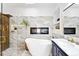 Stunning bathroom featuring a soaking tub, a glass shower, and marble tiling with gold fixtures at 31969 Robinson Hill Rd, Golden, CO 80403