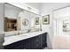 Bathroom with double vanity featuring a large mirror, marble countertop, and storage at 31969 Robinson Hill Rd, Golden, CO 80403