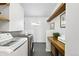 Laundry room featuring modern washer and dryer with gray tile flooring and wood shelving at 31969 Robinson Hill Rd, Golden, CO 80403