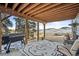 Covered outdoor patio with grill, seating, and picturesque mountain views at 31969 Robinson Hill Rd, Golden, CO 80403