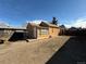 Back of property with dirt yard and exterior of the building under blue sky at 723 Newton St, Denver, CO 80204