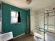 Bathroom with blue walls, a sink, a toilet, a tub/shower combination, and some storage shelves at 723 Newton St, Denver, CO 80204