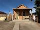 Front elevation of a compact home featuring a covered porch and a small, decorative front bench at 723 Newton St, Denver, CO 80204