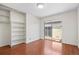 Bright bedroom with wood floors, built-in shelves and sliding glass door at 3512 S Kittredge St # A, Aurora, CO 80013