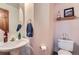 Charming half bathroom featuring a pedestal sink and toilet, with elegant decor providing a cozy space at 8426 W 97Th Pl, Broomfield, CO 80021