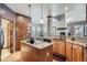 Well-appointed kitchen with stone countertops, wood cabinets, and modern appliances, with easy access to the dining room at 8426 W 97Th Pl, Broomfield, CO 80021