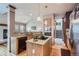 Bright kitchen features granite counters, island with cooktop, and seamless flow into living spaces at 8426 W 97Th Pl, Broomfield, CO 80021