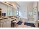 Elegant main bathroom featuring a double vanity, soaking tub, and glass-enclosed shower at 8426 W 97Th Pl, Broomfield, CO 80021