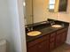 Bathroom featuring a double sink vanity with granite countertops and dark wood cabinetry at 4995 S Algonquian Way, Aurora, CO 80016