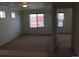 Spacious room with neutral walls, large windows, plush carpet, and an open doorway to a connected room at 4995 S Algonquian Way, Aurora, CO 80016