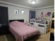 This bedroom features a pink quilt, a lofted bed and unique recessed display shelves for personal decoration at 4995 S Algonquian Way, Aurora, CO 80016